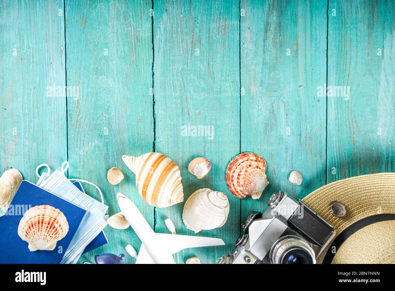Bright  summer flat-lay background. Old blue wooden background with with summer woman clothes, sun glasses, hat, camera, passports and vacation ticket Stock Photo