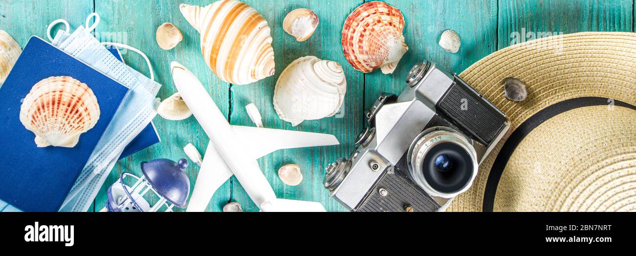 Bright  summer flat-lay background. Old blue wooden background with with summer woman clothes, sun glasses, hat, camera, passports and vacation ticket Stock Photo