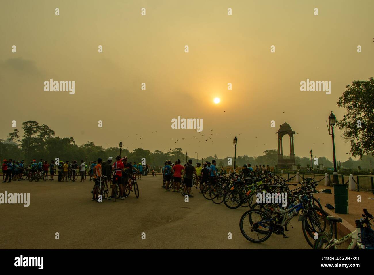 Cyclists gather in front of India gate at Rajpath road near Amar Jawan Jyoti at sunrise. Stock Photo