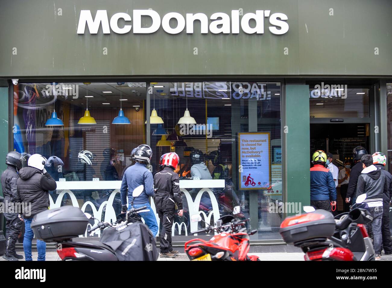 London, UK.  13 May 2020.  Delivery riders wait for orders as the McDonald's fast food restaurant in Harrow reopens for 'McDelivery' during the ongoing coronavirus pandemic.  The restaurant is one of 14 in the UK that the chain is partially reopening with a limited menu and delivery only.  Delivery is satisfied by third parties such as Uber Eats and Deliveroo.  Credit: Stephen Chung / Alamy Live News Stock Photo