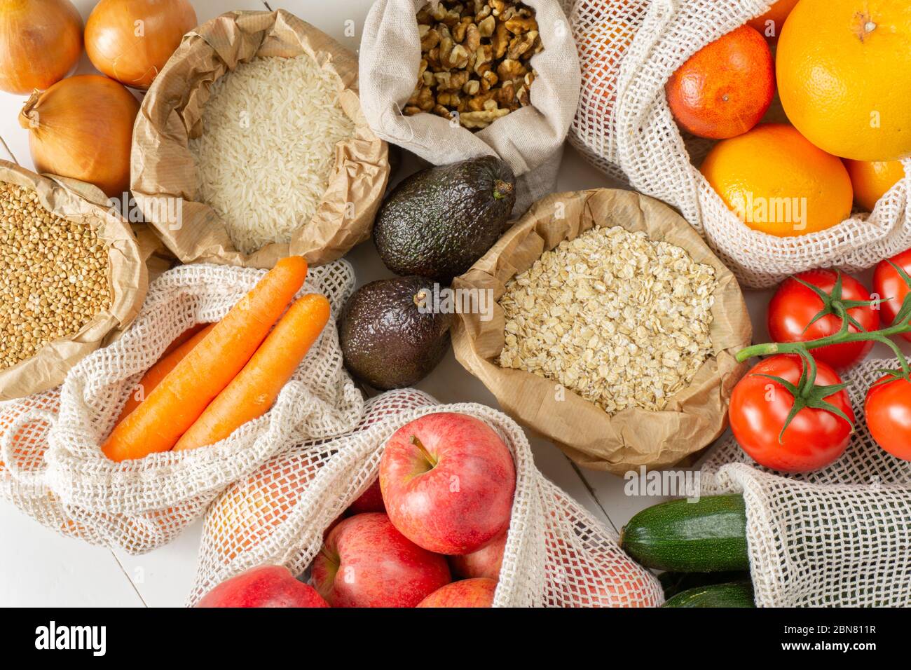 Groats, fruits, vegetables, nuts in paper and cotton bags. Top view. Zero waste, eco friendly or plastic free lifestyle concept. Stock Photo