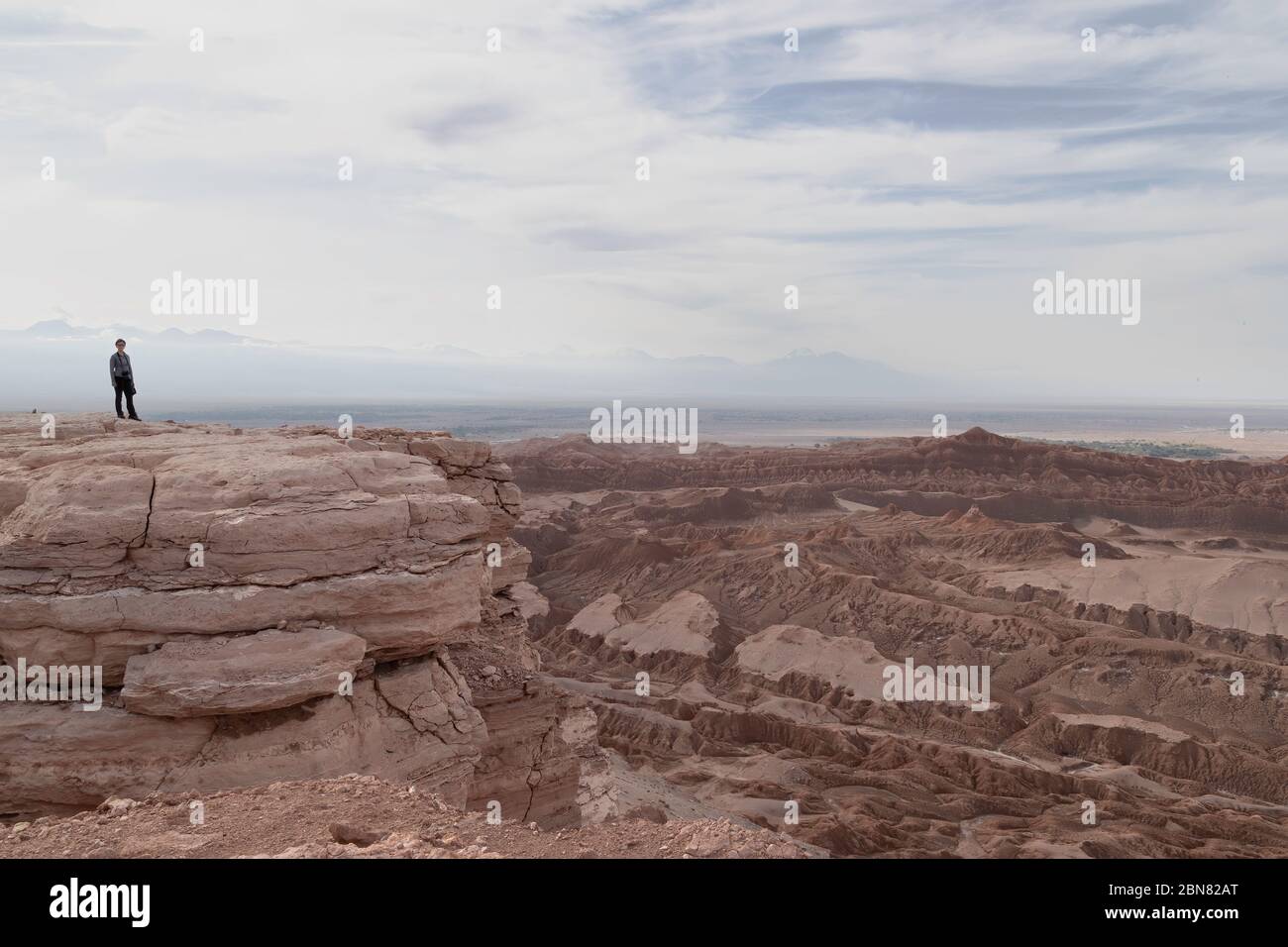 single person looks out at the view over the Valley of the Moon from Mirador de Kari, Piedra del Coyote , San Pedro de Atacama, Antofagusta, Chile Stock Photo