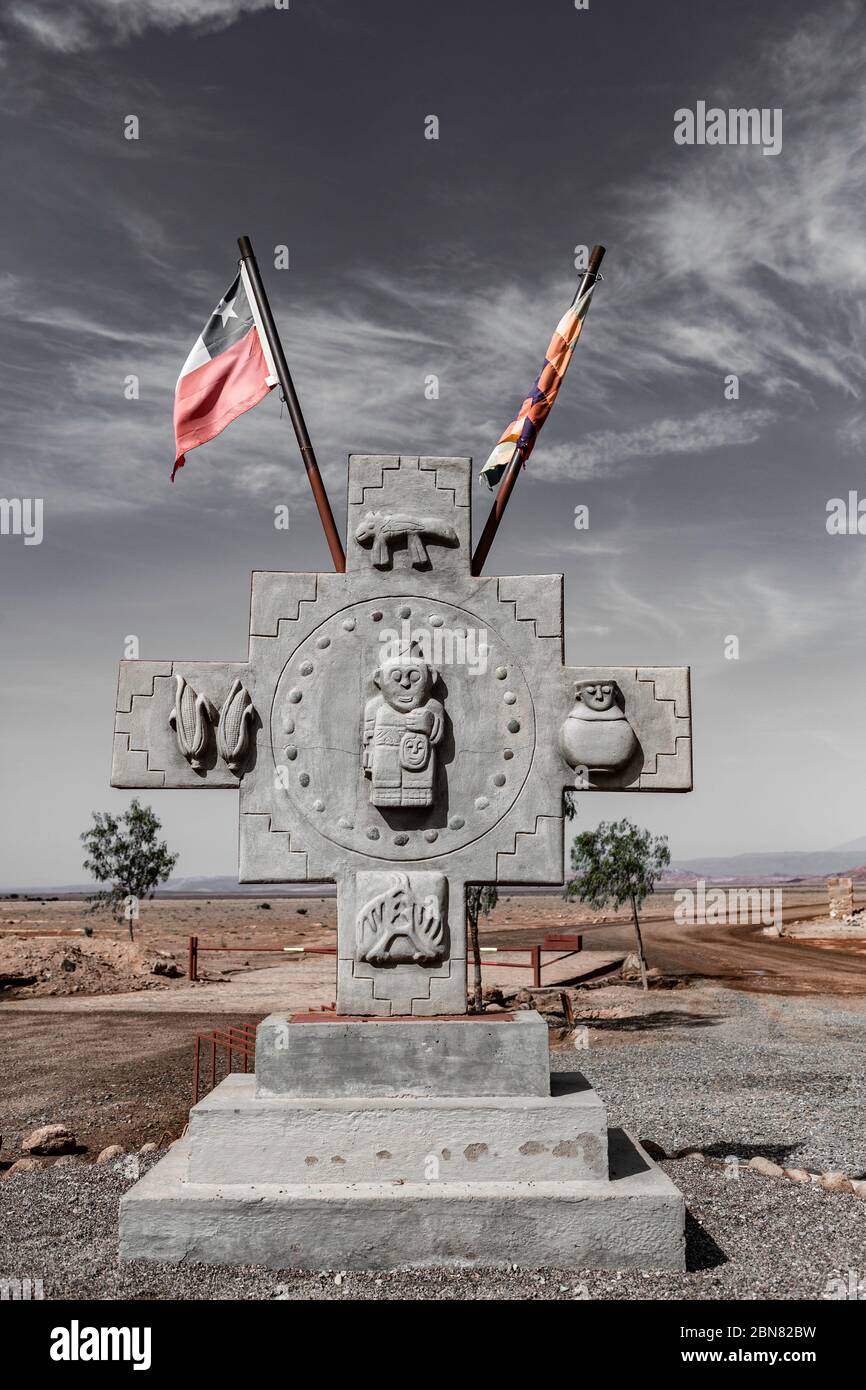 Inca Cross monument With flags Of the Aymara people and of Chile at The Valle De La Luna, San Pedro de Atacama, Chile Stock Photo