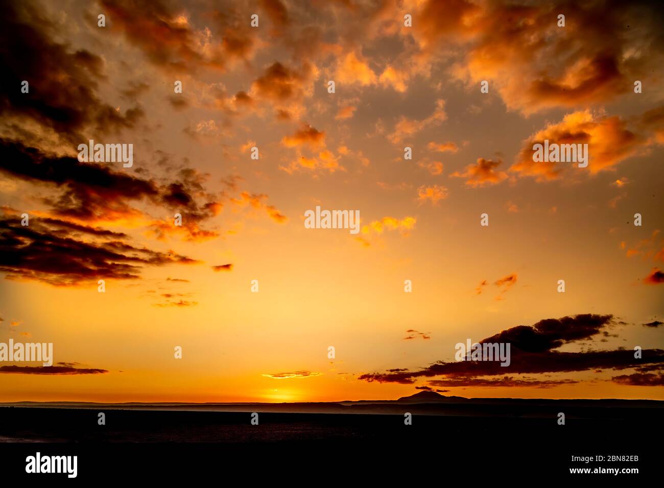 Sunset seen from the western side of Laguna Tebinquiche, San Pedro de Atacama.  Looking west towards Cerro Quimal and the Chilean Coastal Range. Stock Photo