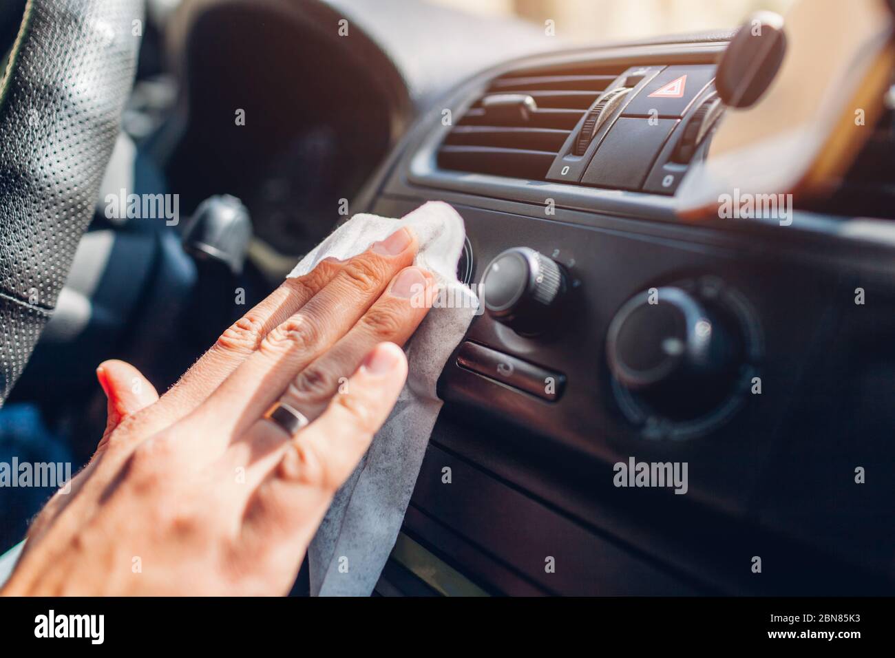 Coronavirus car disinfection. Man cleans interior surfaces with wet
