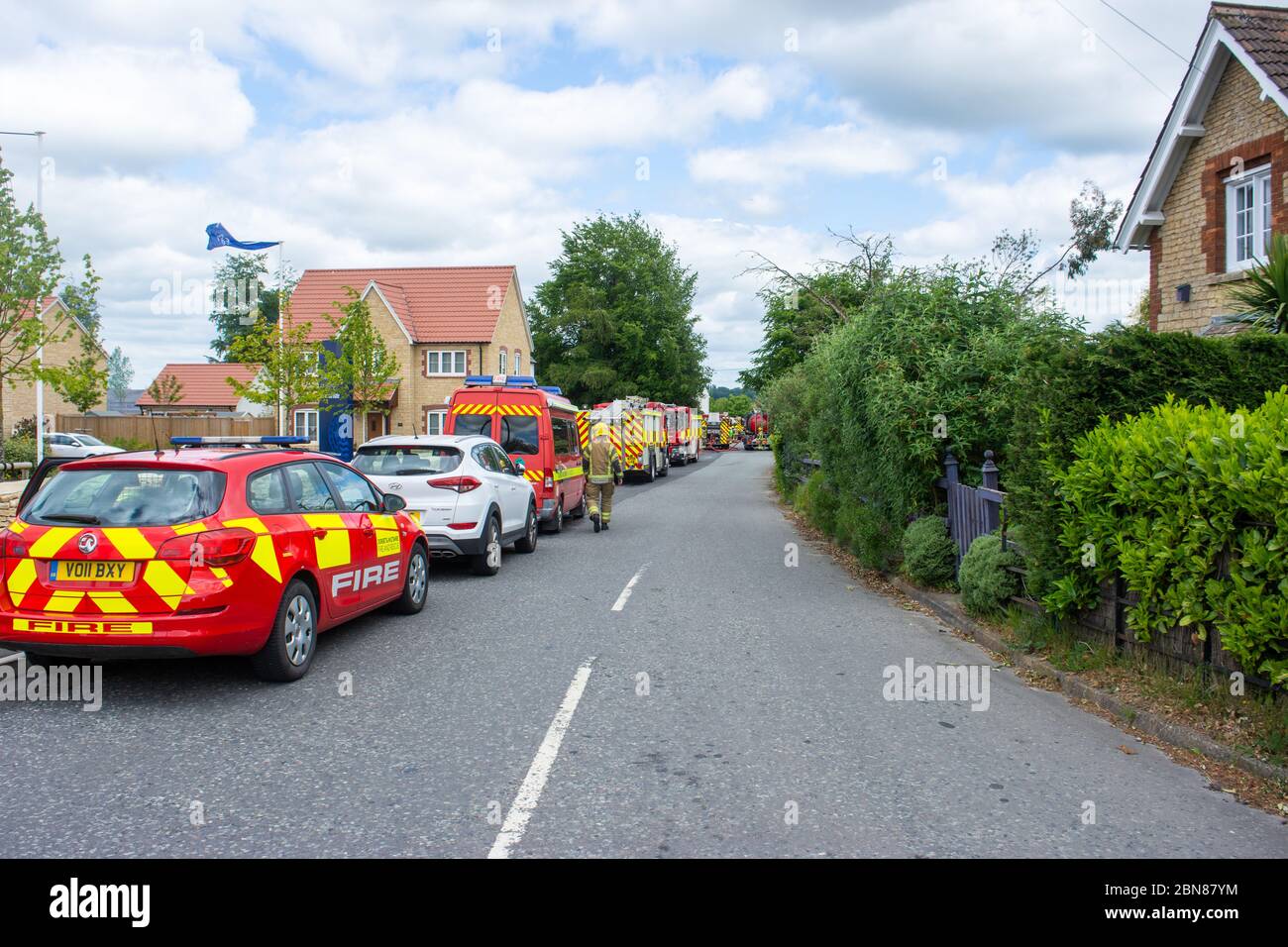 Fire brigage vehicles including engines and cars parked down the side