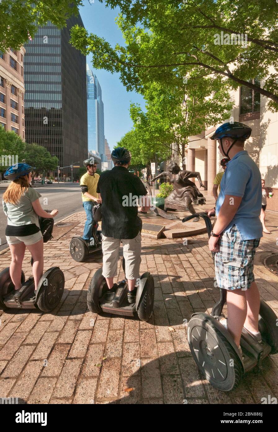 Tourists on Segway PT two-wheeled personal transporters at sculpture of Angelina Eberly firing a cannon, Congress Avenue, Downtown Austin, Texas, USA Stock Photo