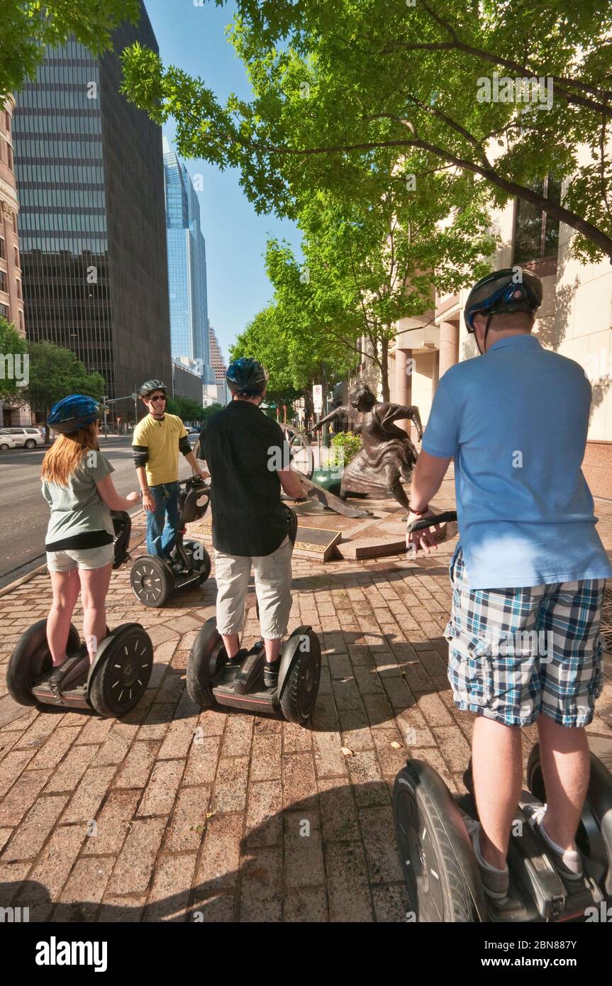 Tourists on Segway PT two-wheeled personal transporters at sculpture of Angelina Eberly firing a cannon, Congress Avenue, Downtown Austin, Texas, USA Stock Photo