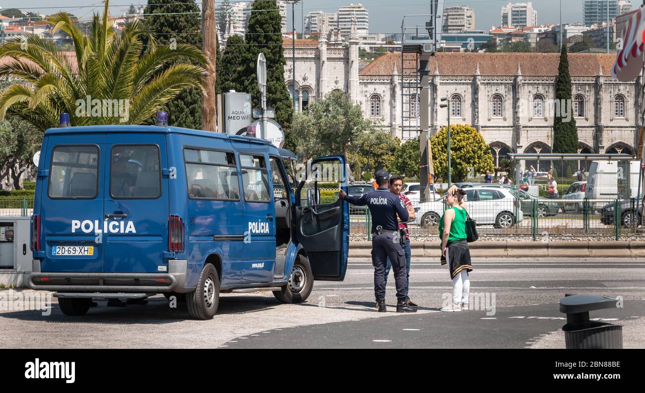 Lisbon, Portugal - May 7, 2018: Policeman chatting with passers-by next to a Portuguese police truck in the historic city center on a spring day Stock Photo