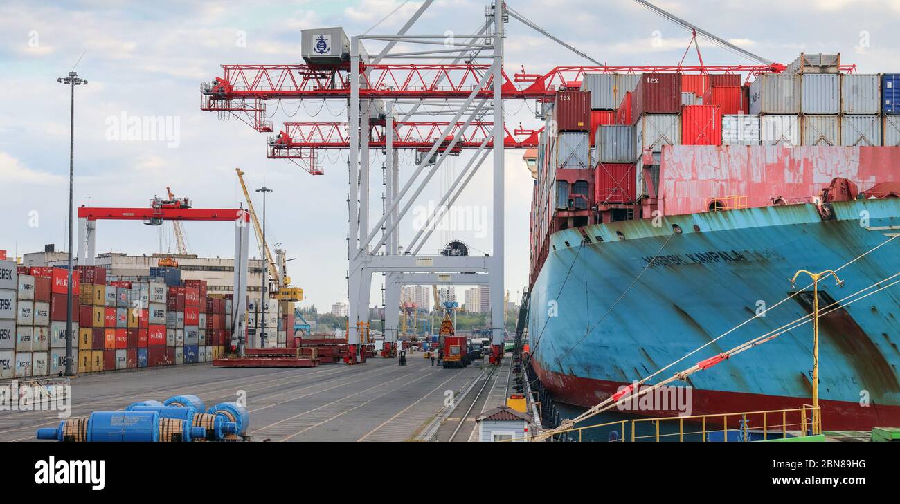 SINGAPORE - MAY 08 2020: Container cargo ship load in the seaport. Logistics and transportation of Container Cargo ship with working crane bridge in s Stock Photo