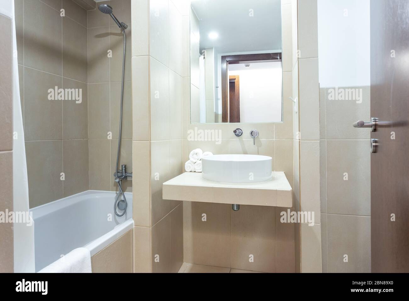 Modern bathroom with bathtub, mirror and washbasin. European hotel