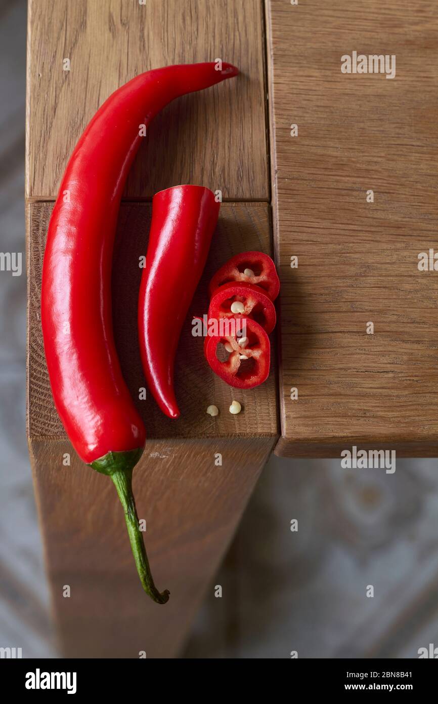 Close-up of sliced red hot chili peppers on wooden table, selective focus Stock Photo
