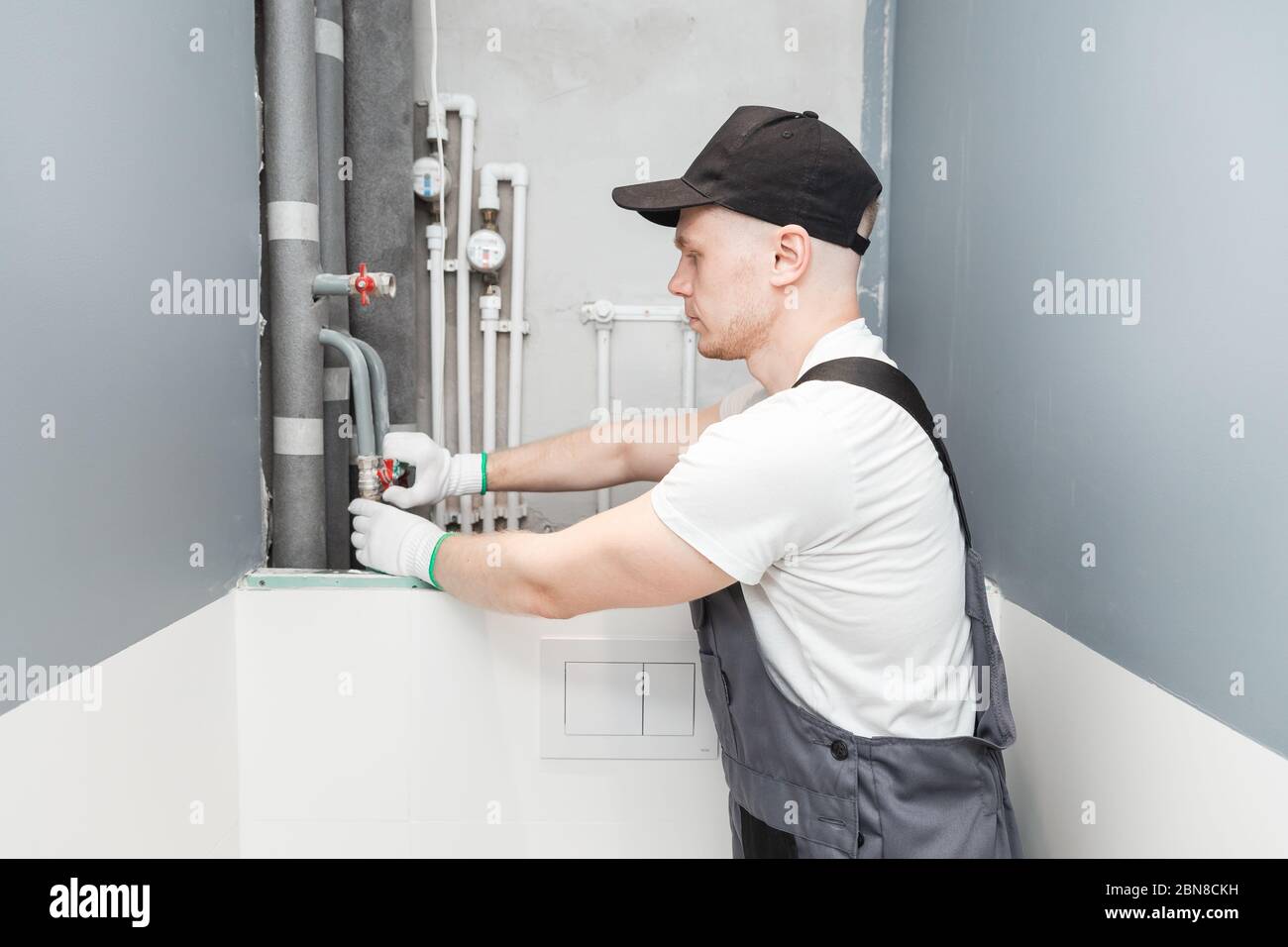 Male plumber checks pipes for central hot and cold water supply of