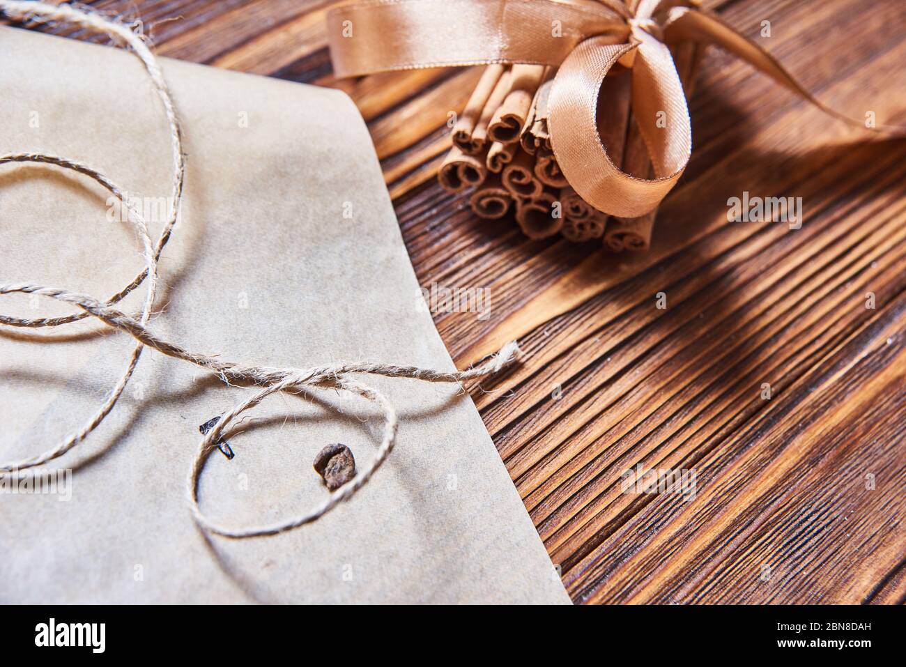 cinnamon sticks tied with brown ribbon on wooden background Stock Photo