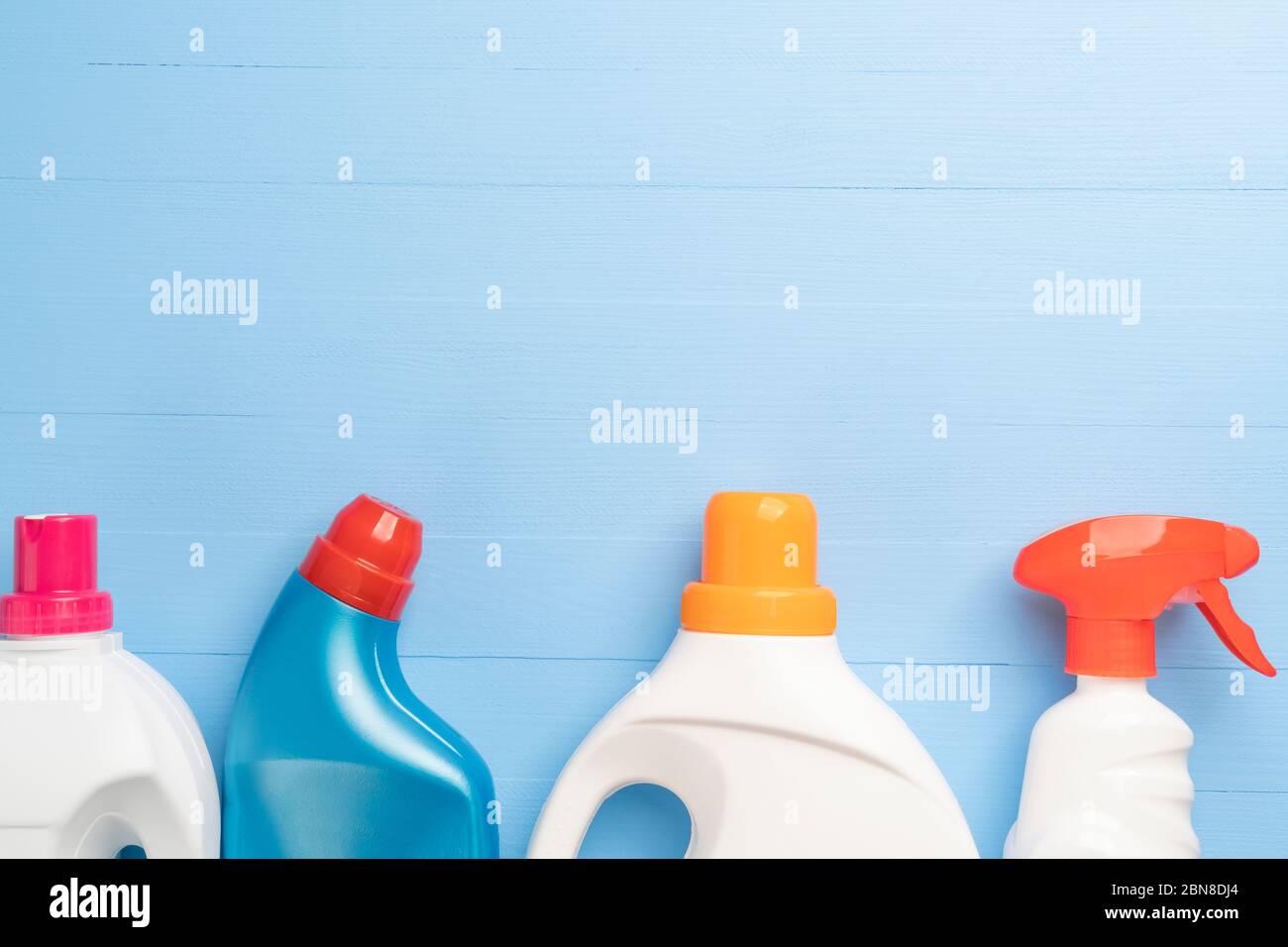 Set of detergents and cleaners in bright plastic bottles for homework and cleaning on a wooden light blue background. Copyspace. Anti Coronavirus Disi Stock Photo