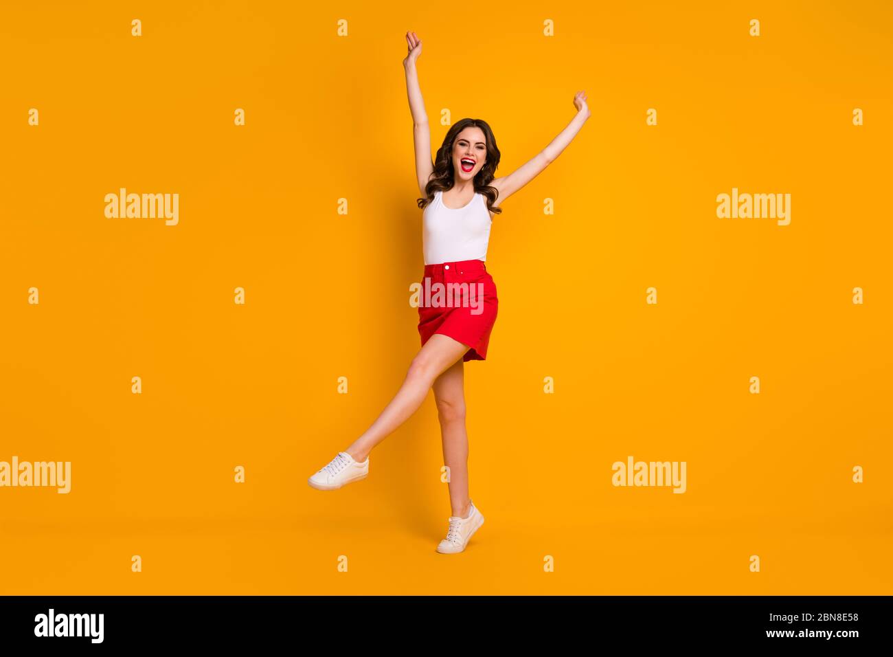 Full length photo of funny cheerful lady raise hands one leg weekend sunny  weather summer wear casual white tank-top red mini skirt shoes isolated  Stock Photo - Alamy