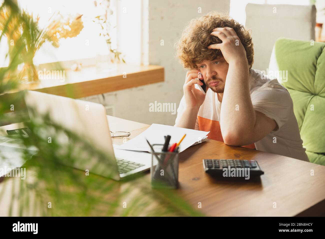 Caucasian upset and despair man watching financial and economical reports with income reduction during coronavirus quarantine, problems. Worldwide crisis. Lack of money, business fall, empty wallet. Stock Photo