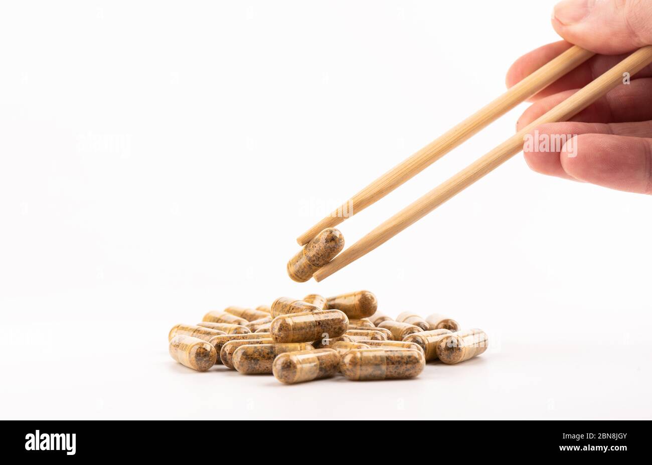 Man's hand holds chopsticks with a medical tablet. Health concept. Copy space. Stock Photo