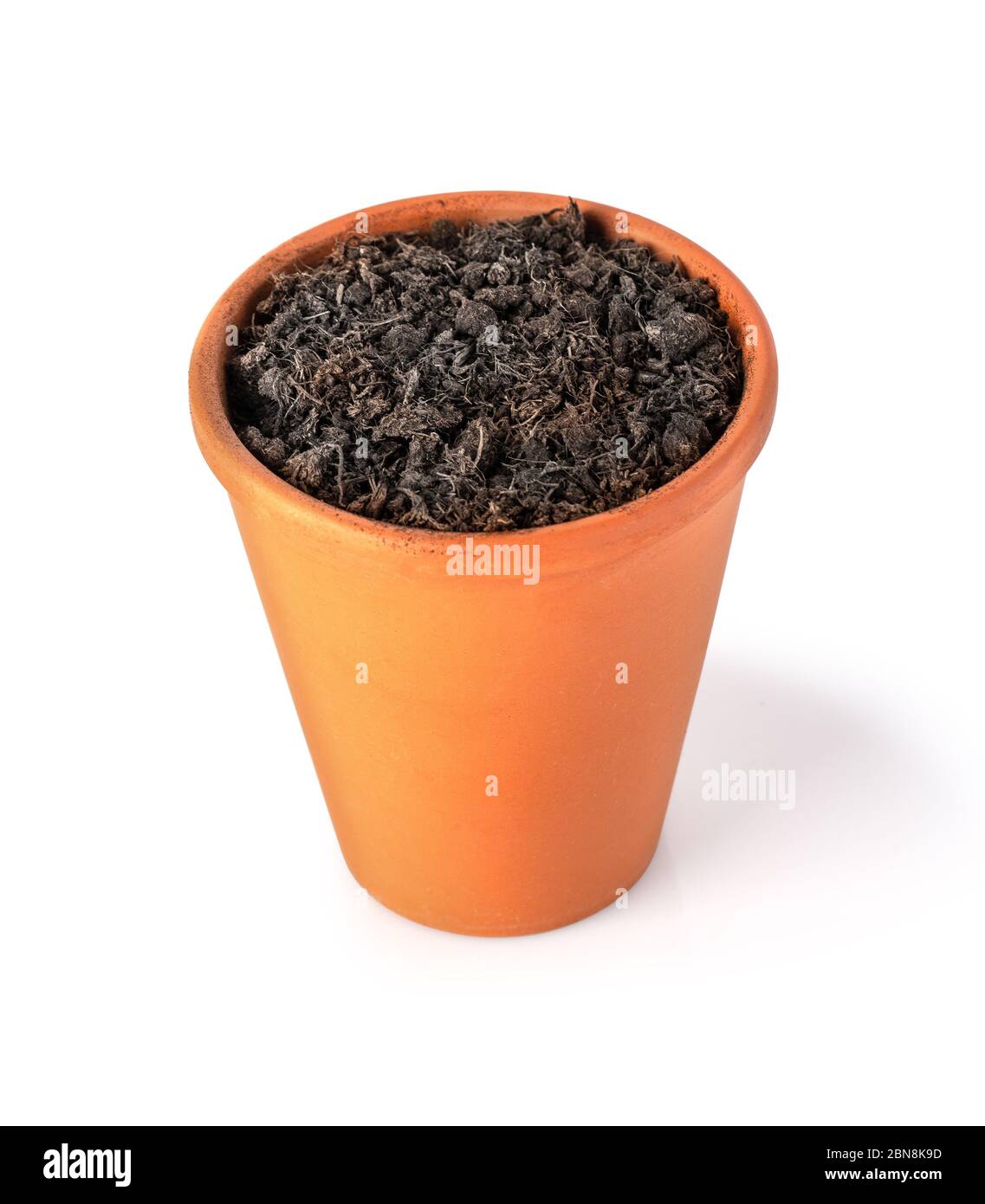 clay pot filled with organic potting soil on a white background with clipping path Stock Photo