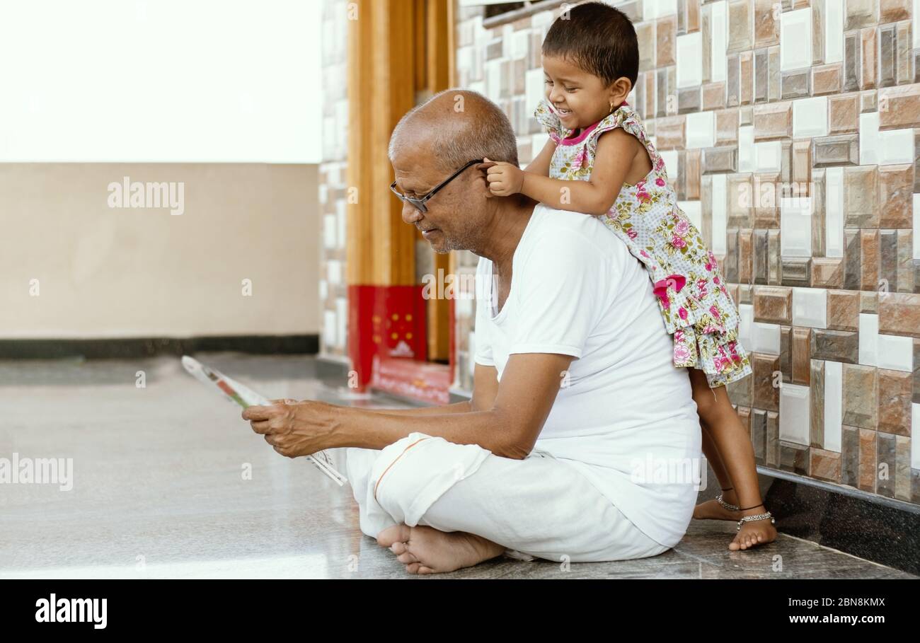 little granddaughter Little Granddaughter playing with grandfather by pulling grandpa's ears at  home - concept of togetherness, fun, happiness and kids relationship with  Stock Photo - Alamy