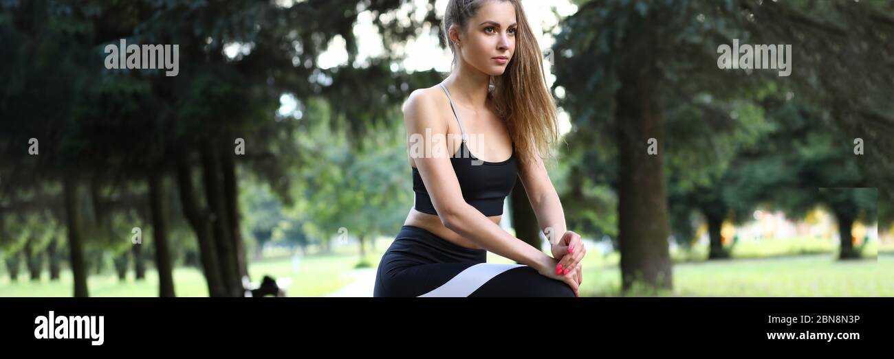 Beautiful girl in sportswear flexes muscles feet. Stock Photo