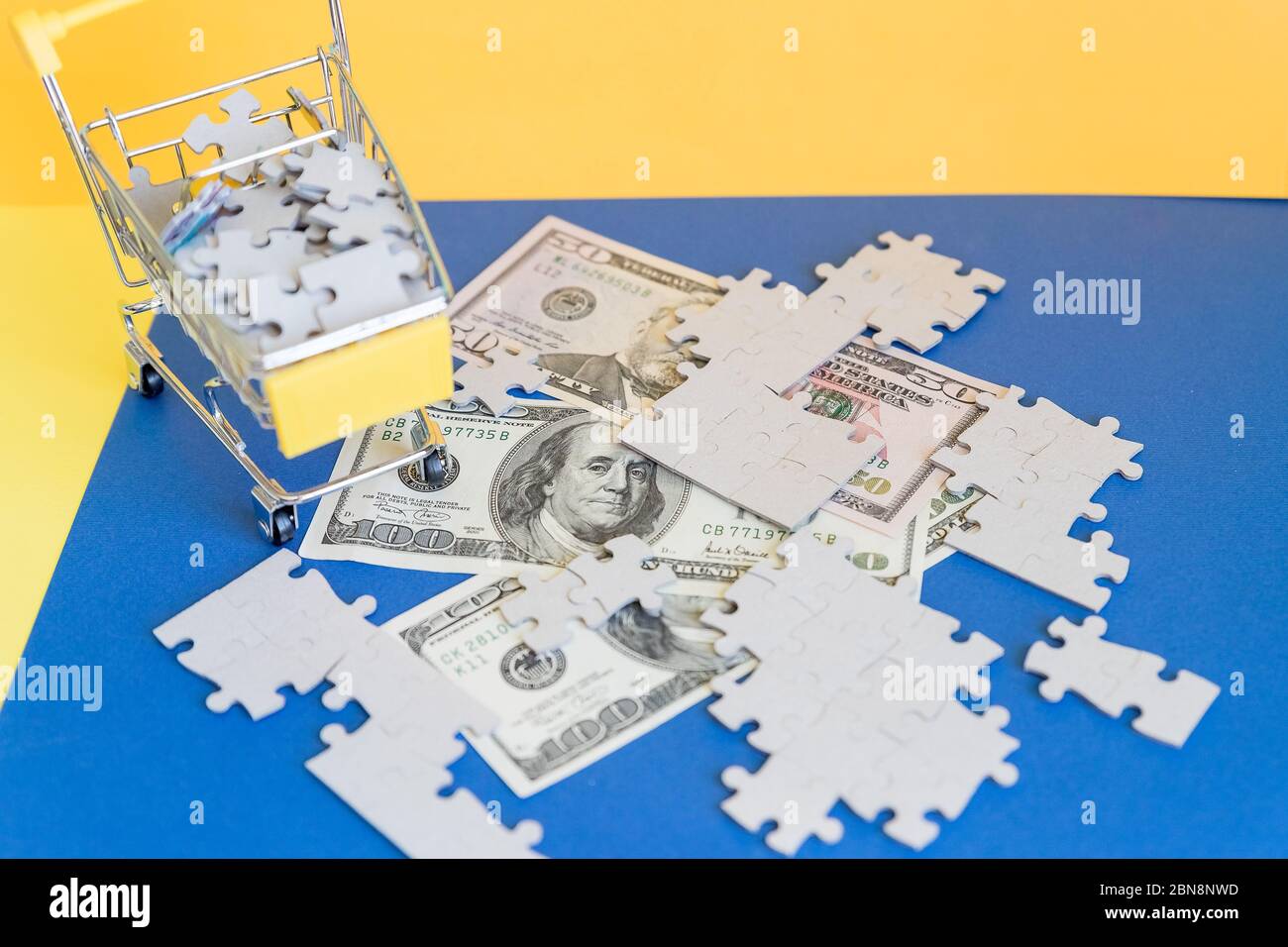 Shopping cart full of jigsaw puzzle on money dollar background