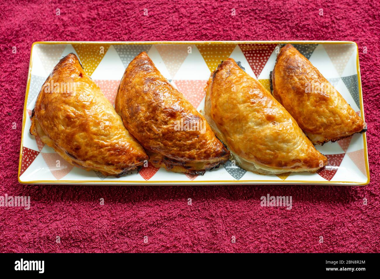 Four nicely browned homemade pastries (apple and pear rissoles) Stock Photo