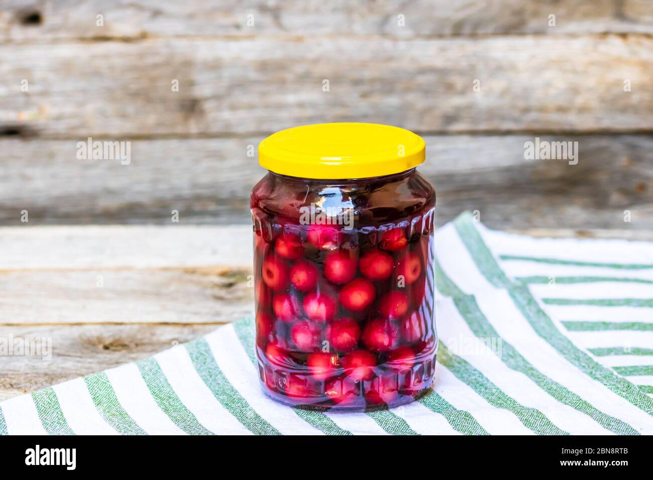 Glass jar with canned cherries fruits. Preserved fruits concept, canned
