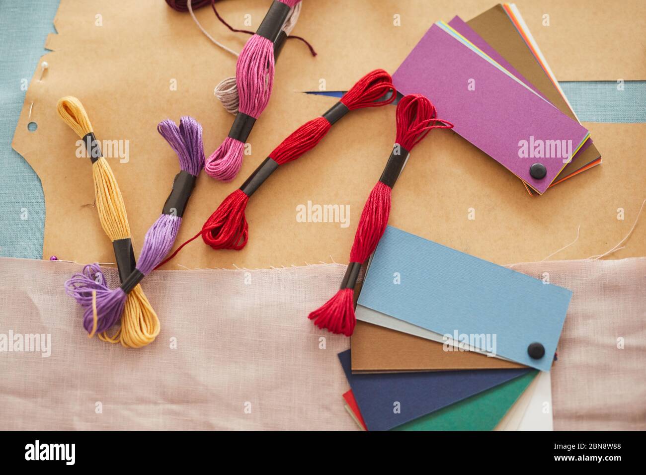 High angle view of colored patterns with threads lying on the table in workshop Stock Photo