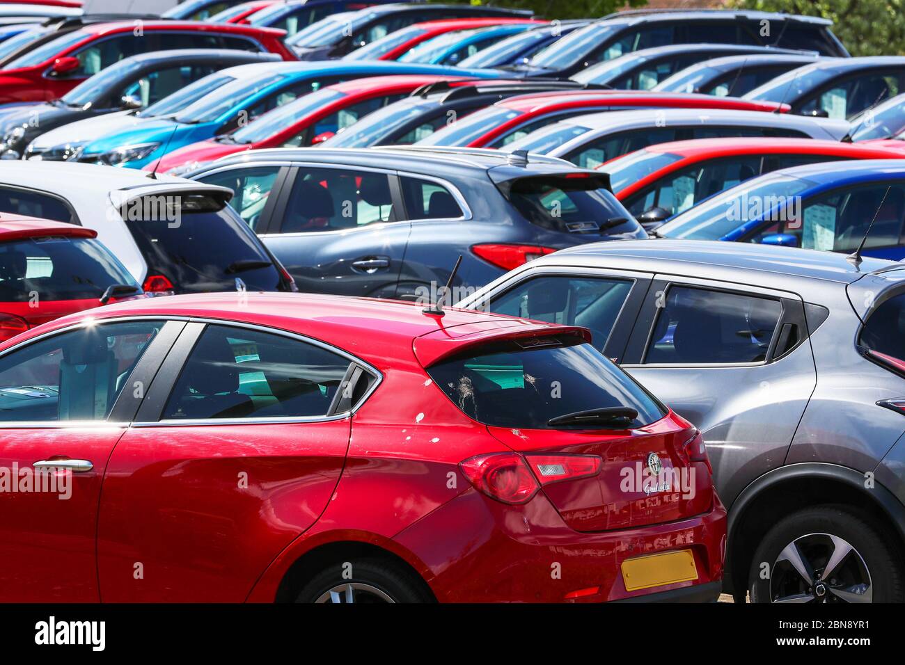 various brands of secondhand used motor cars for sale on a garage