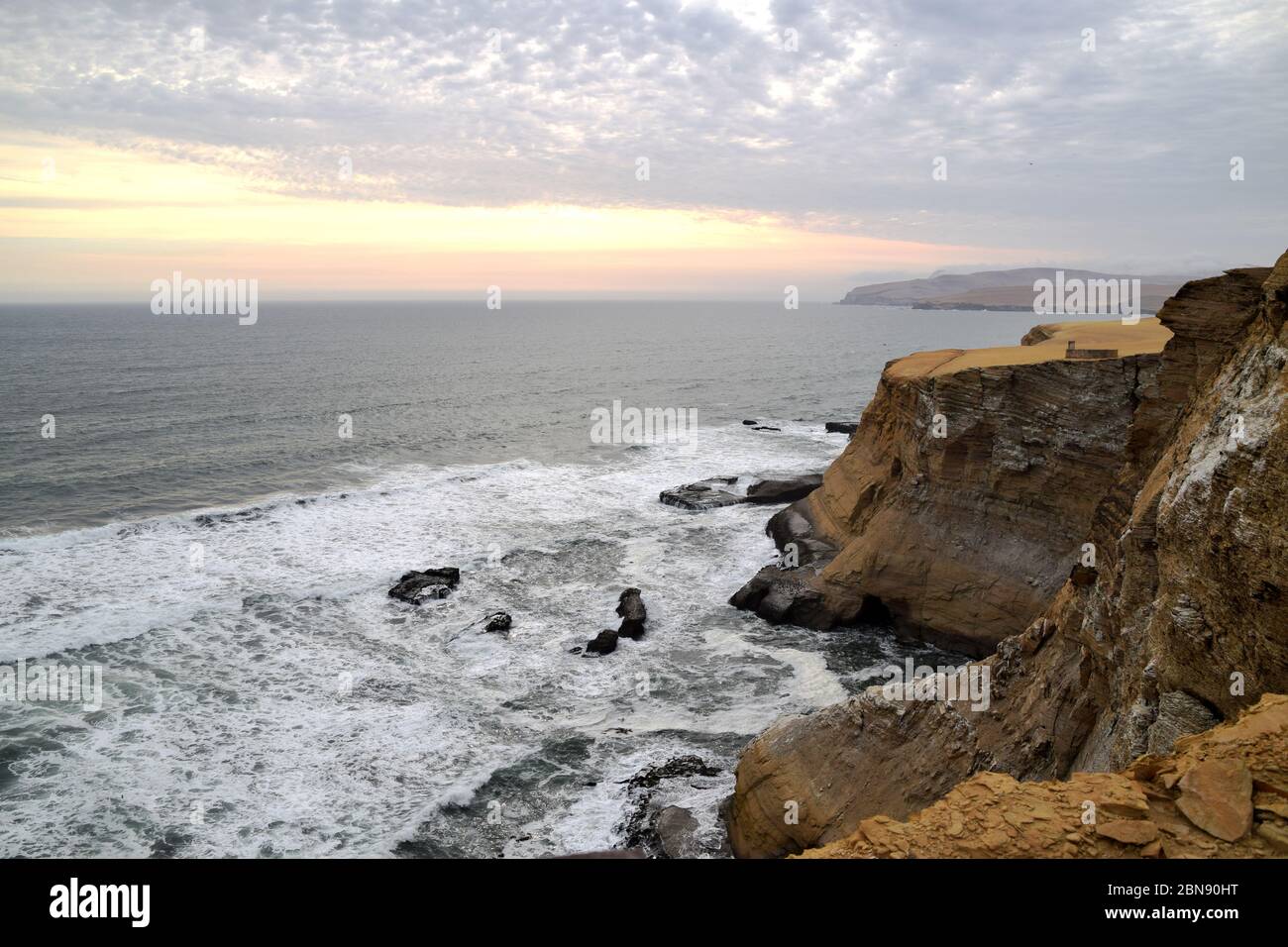 Peru Breaking Rocks Sunset outside Paracas, Peru. Waves coming in, hitting the rocks in the ...
