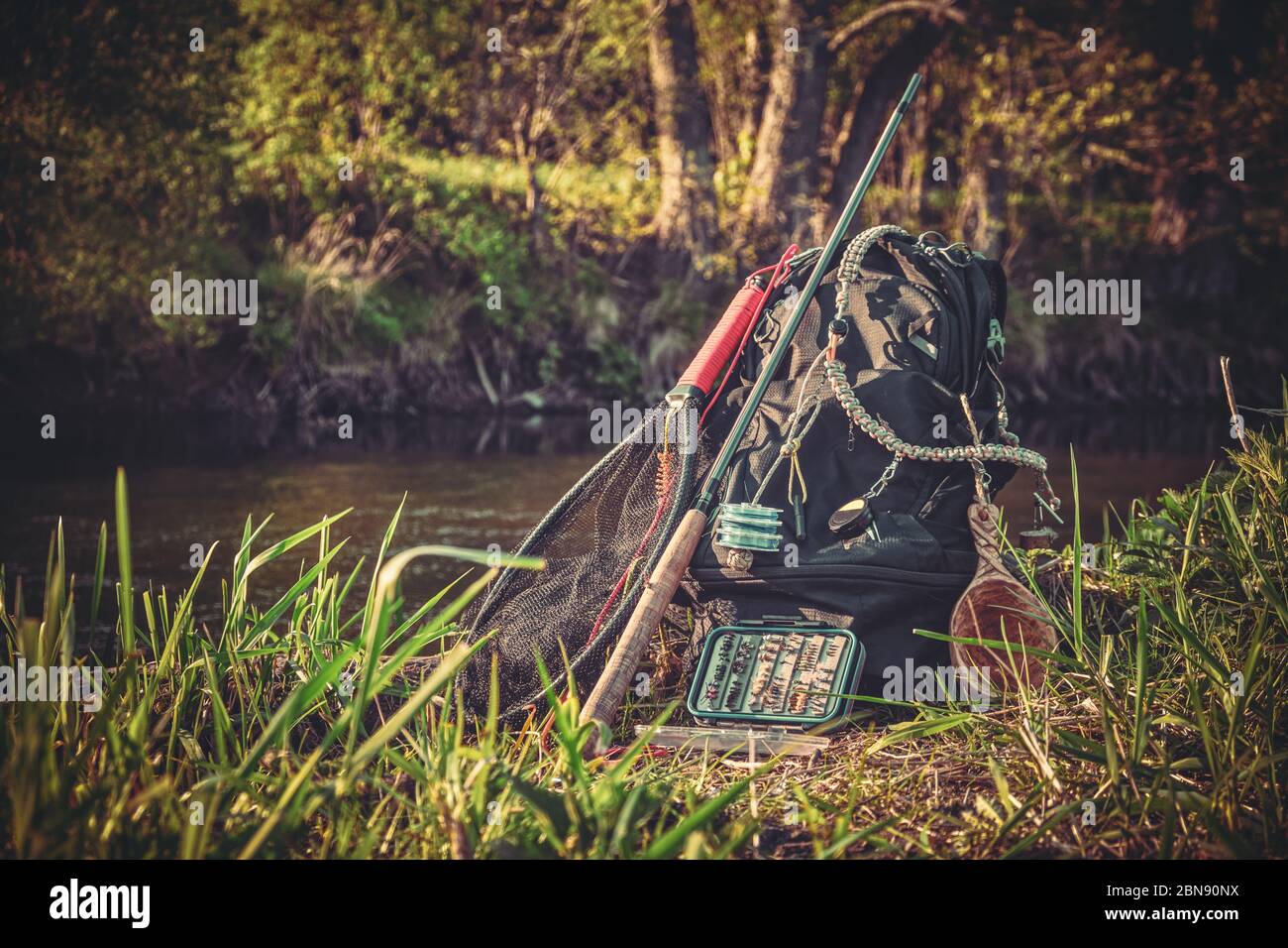 Fishing rod, backpack and fishing gear on the river bank. Tenkara. Stock Photo