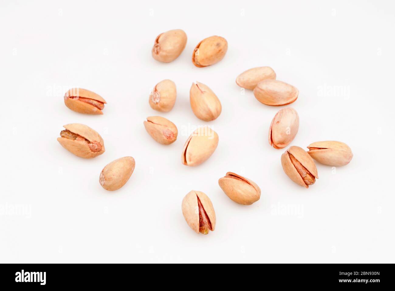 Organic pistachio nuts scattered on white background Stock Photo