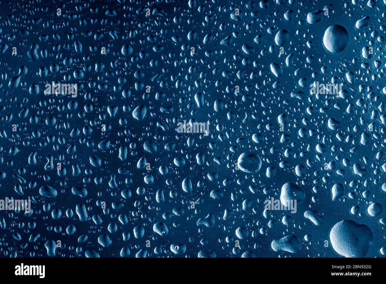 Water drops on window glass. Rain drops on dark trendy blue background.  Macro, closeup Stock Photo - Alamy
