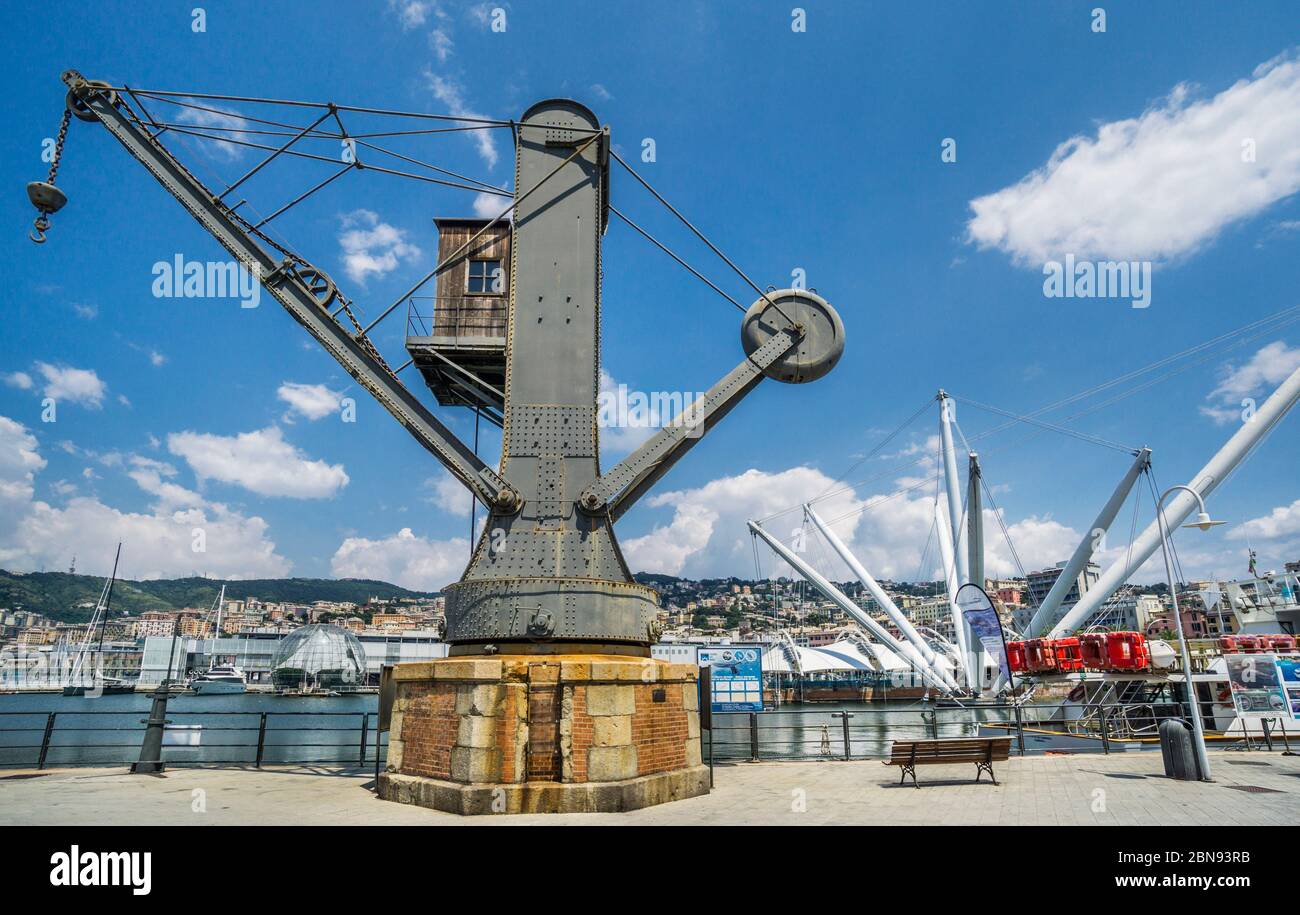 old harbour crane at the Old Harbour of Genoa, against the backdrop of Bigo, crane-inspired lift offering short rides with harbor views. Stock Photo