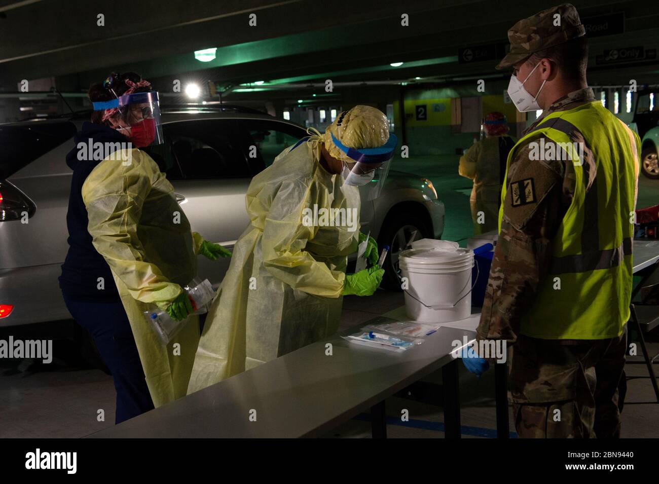 Kennesaw, GA, USA. 13th May, 2020. Free COVID-19 testing continues for anyone who needs at several sites throughout Georgia, supervised by troops from the Georgia Army National Guard and performed by medical staff from Augusta University.Pictured: A nurse, dressed in required personal protective gown, mask and gloves prepares to perform swab test on area resident, waiting in car at Kennesaw State University parking deck. Credit: Robin Rayne/ZUMA Wire/Alamy Live News Stock Photo