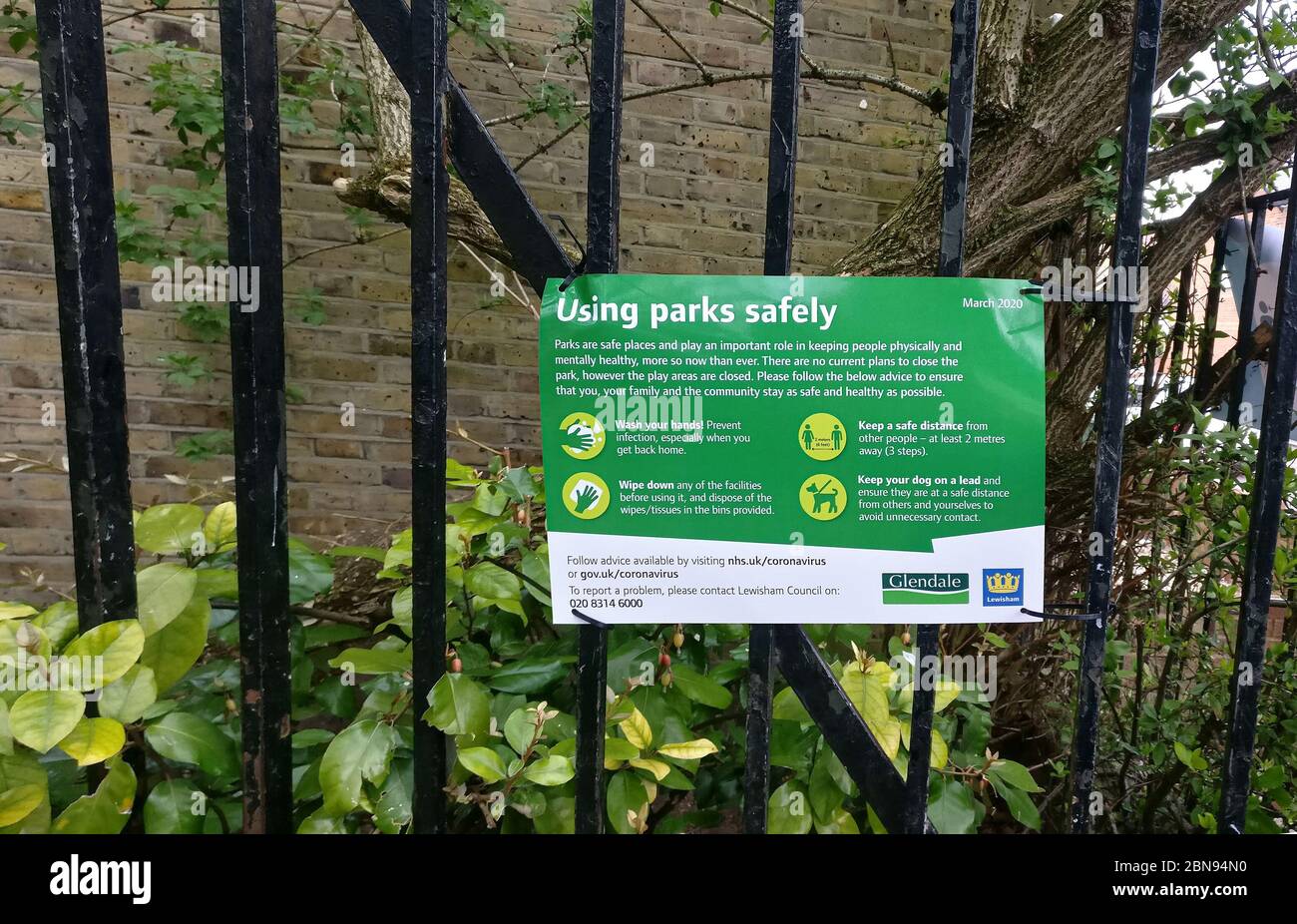 London, United Kingdom - April 03, 2020: Virus prevention advice safety sign on fence in Lewisham park due to coronavirus covid-19. Many public places Stock Photo