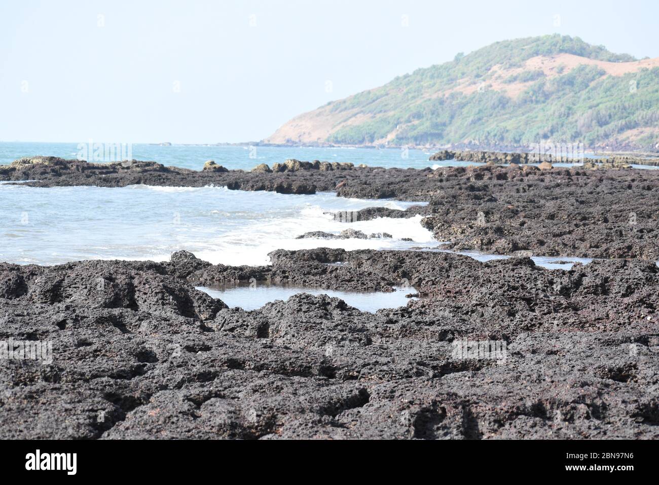 Black rocks in the seashore and mountain in the background..A view from ...