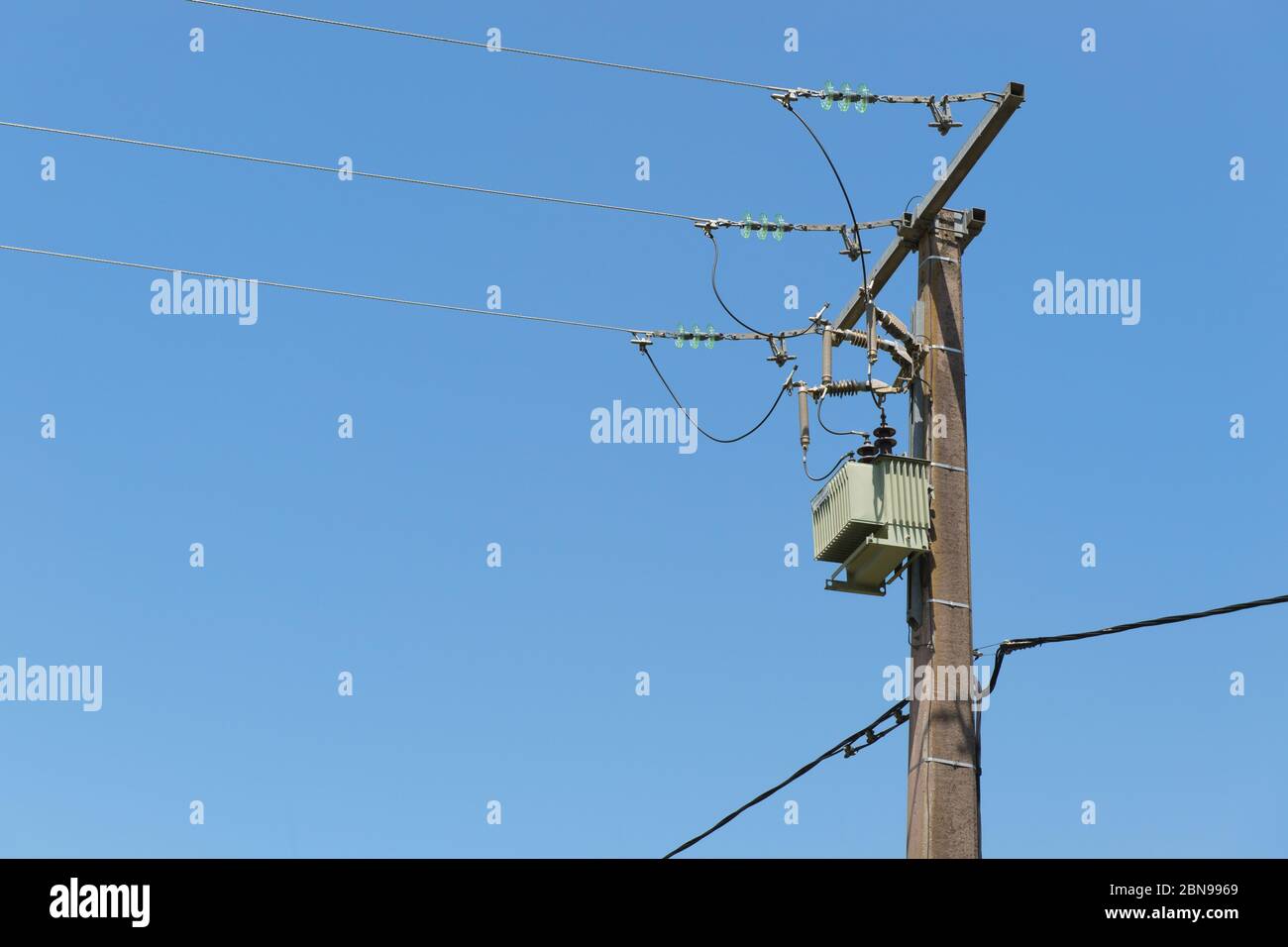 Electricity pole and threads against blue sky Stock Photo - Alamy