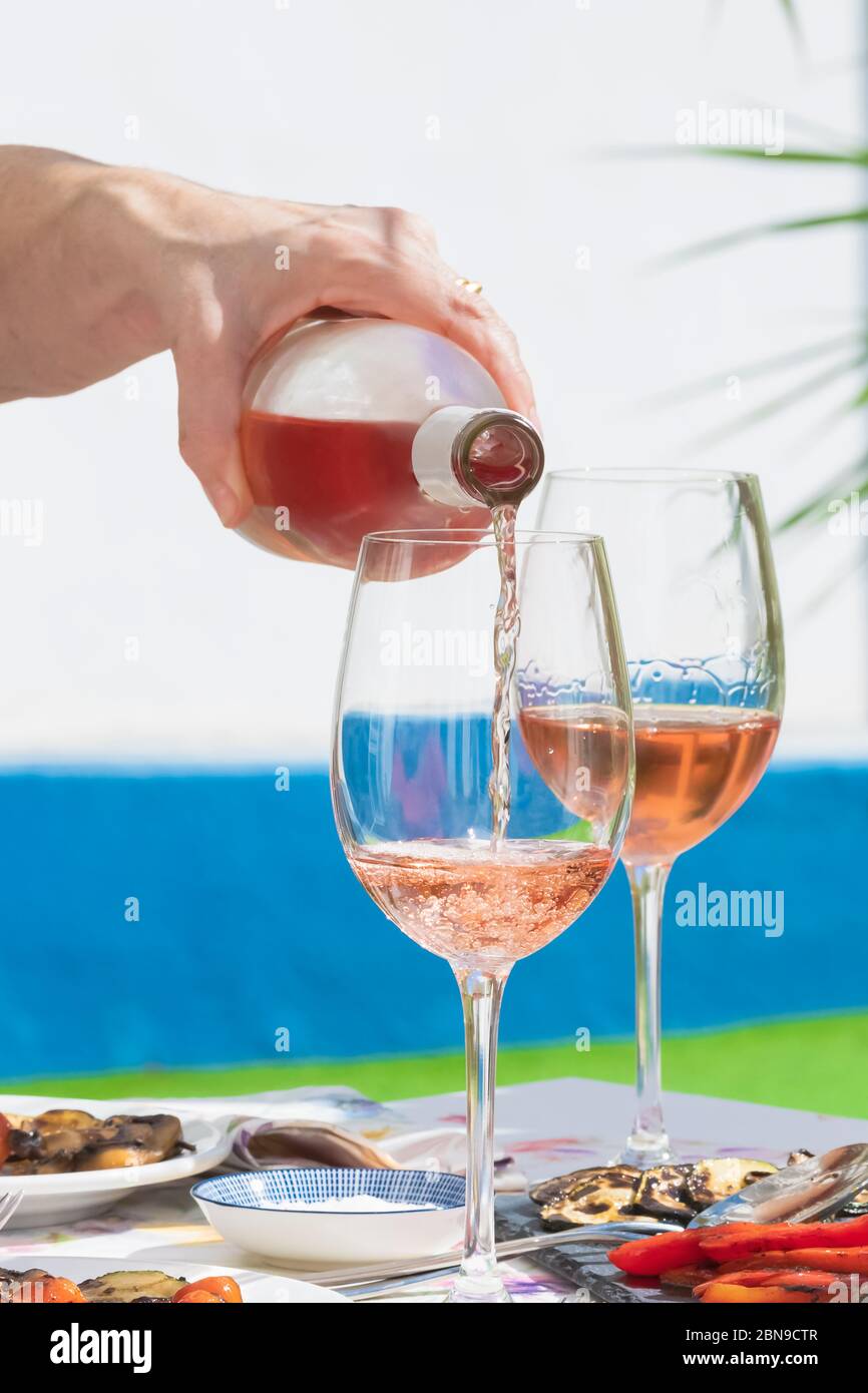 a hand of woman pouring rose wine Stock Photo - Alamy
