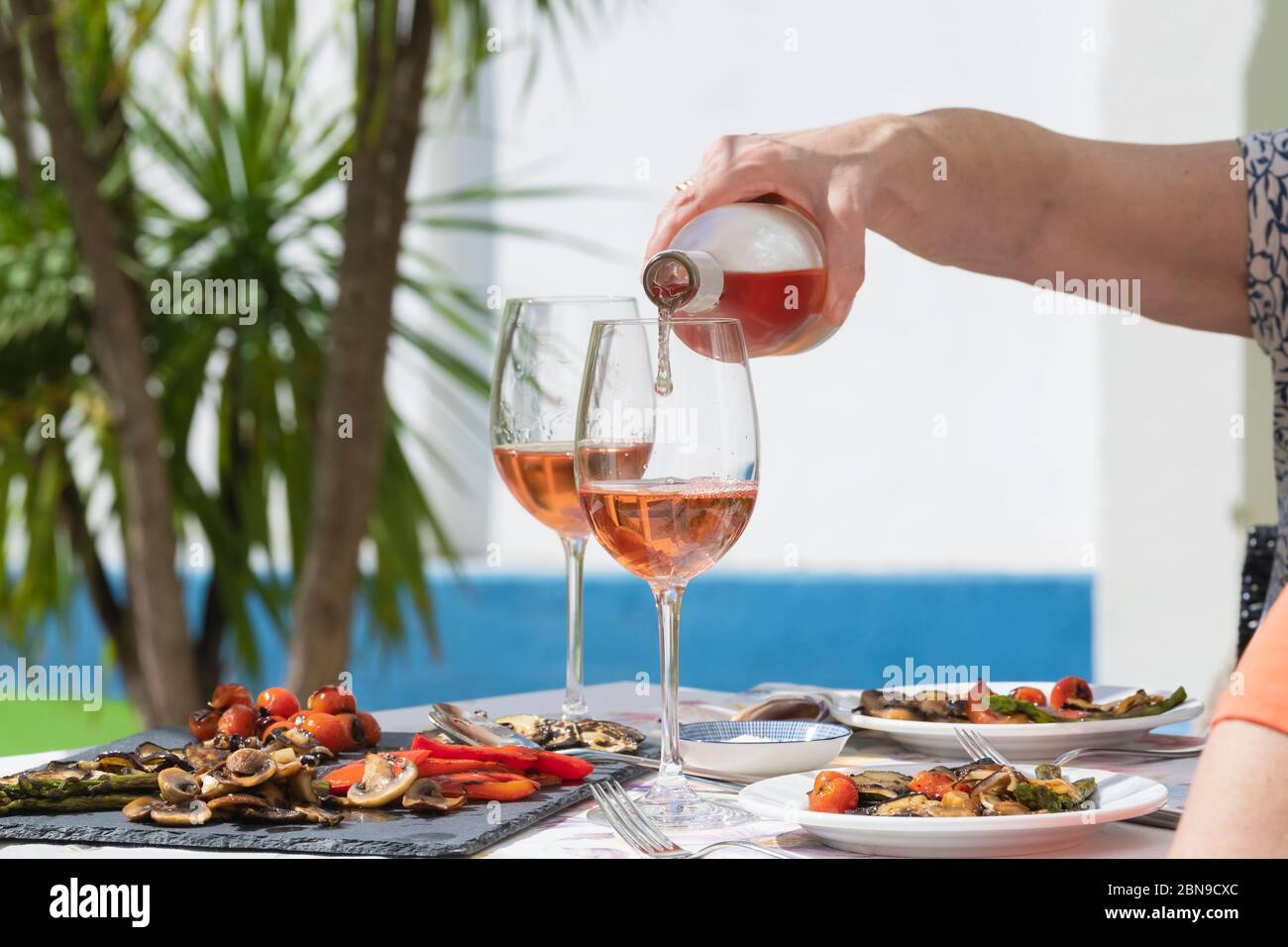 a hand of woman pouring rose wine Stock Photo - Alamy