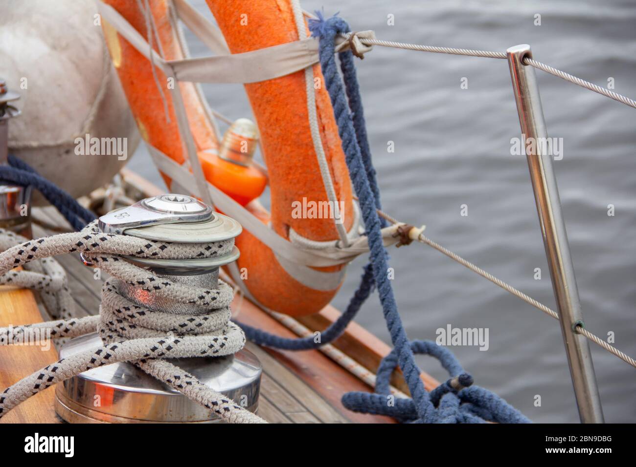 Sailboat winch and rope yacht detail. Nautical part of a yacht with cords, rigging, sail, mast, anchor, knots, lifebuoy Stock Photo