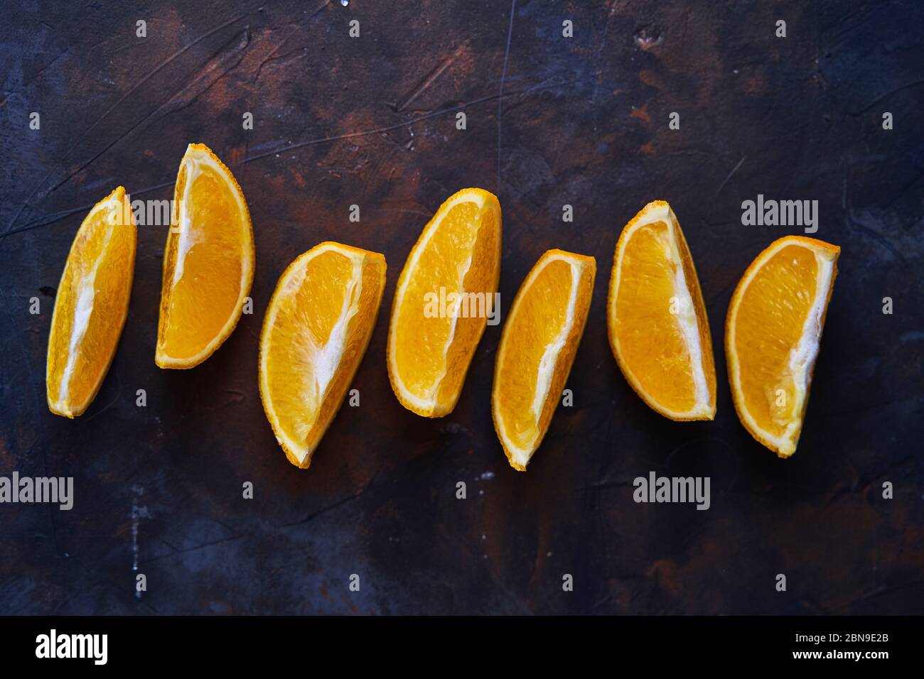 Seven Orange slices on a dark background.  Stock Photo