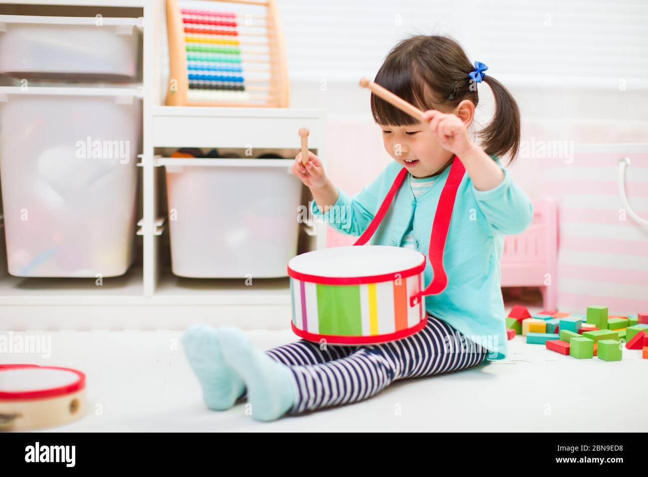 toddler girl play drum at home for homeschooling Stock Photo Alamy