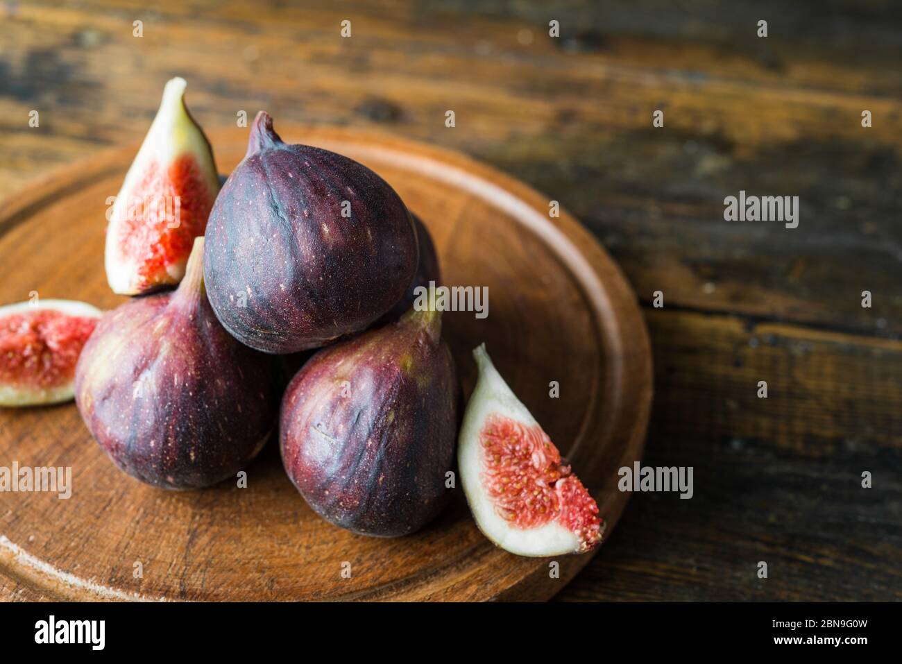 Close up of figs fruit against brown wooden background. Stock Photo