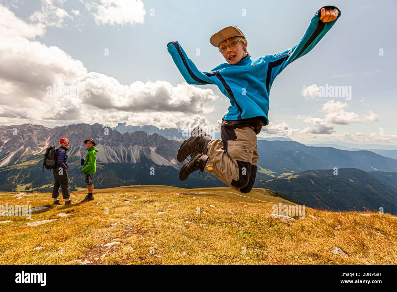 Young Hiker jumping in the Air in the mountains of Alto Adige, Italy Stock Photo