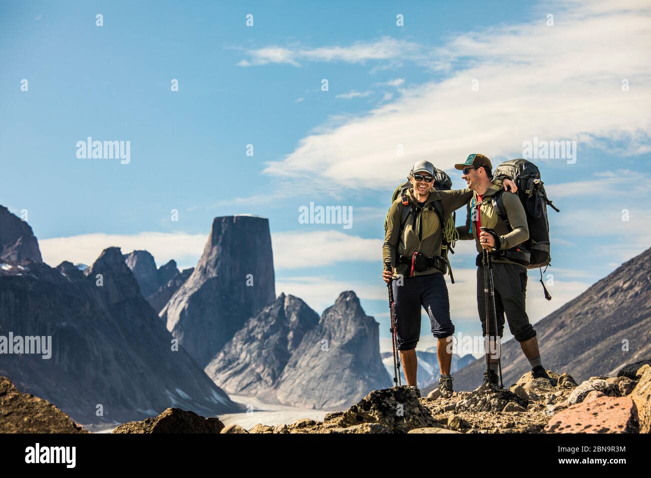 Two happy backpackers laugh while on high mountain ridge with view ...