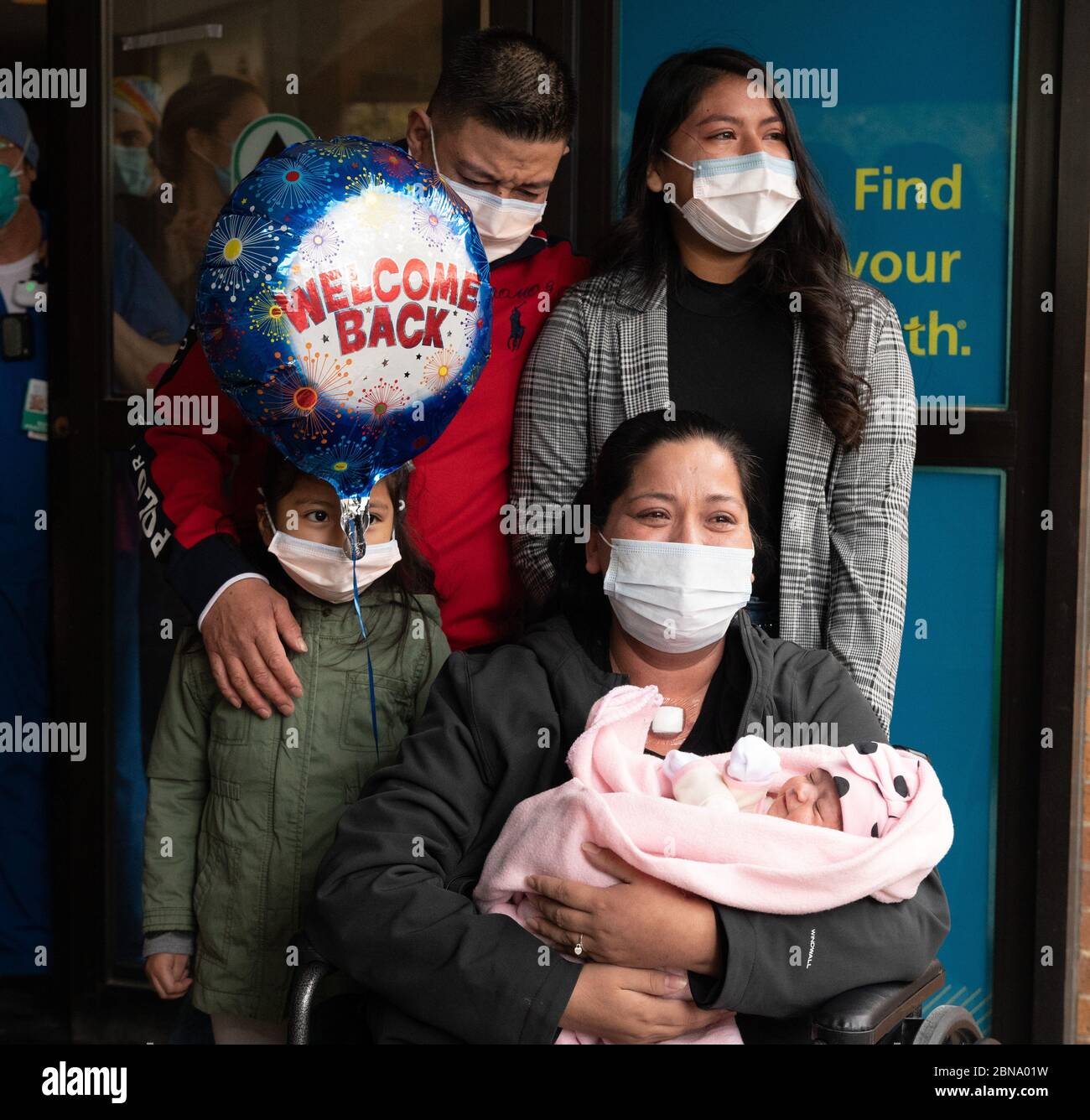 May 12, 2020, Cambridge, Massachusetts USA: Isabel Gonzalez seeing her baby Victoria for the first time, when she is discharged from COVID-19 Recovery Unit Spaulding Hospital in Cambridge. Gonzalez, 34-year old from Chelsea, MA who was pregnant when she contracted COVID-19, delivered her baby Victoria via emergency C-section at Massachustts General Hospital on March 30, when she was initially admitted. She was transferred to the ICU on April 2nd, intubated and was on a ventilator until April 26th. She was admitted to Spaulding Hospital Cambridge on May 4th and now has tested COVID negative a Stock Photo