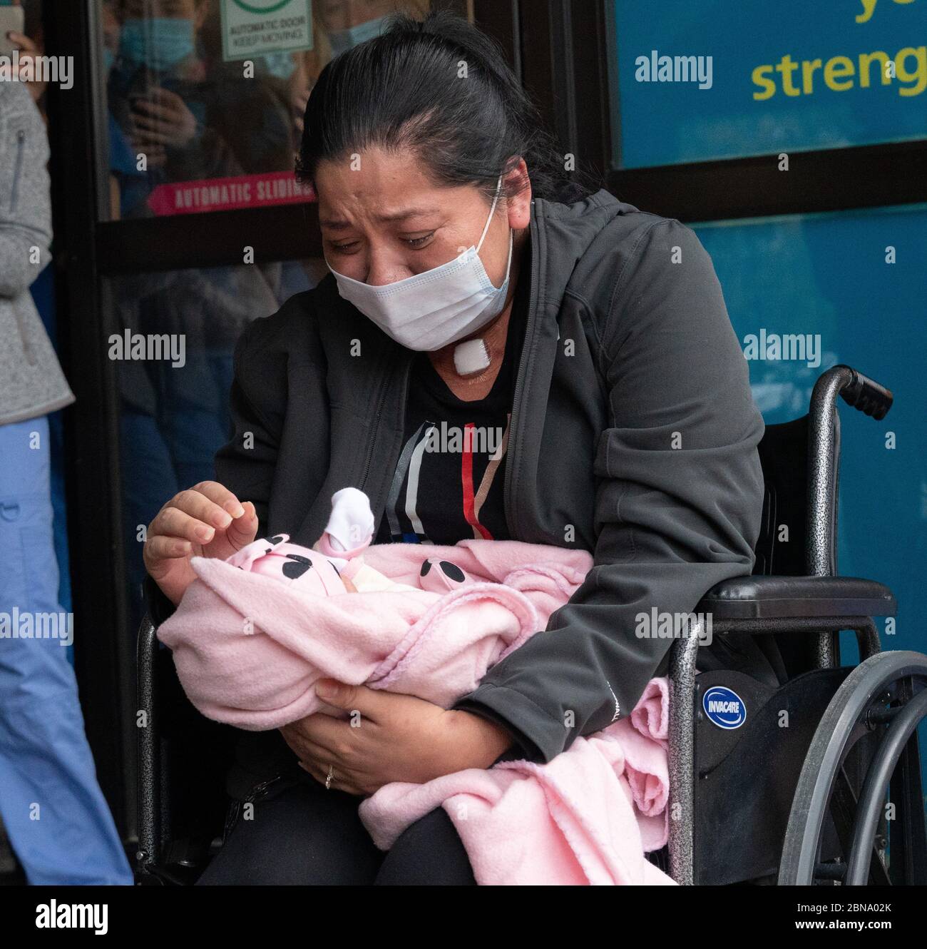 May 12, 2020, Cambridge, Massachusetts USA: Isabel Gonzalez seeing her baby Victoria for the first time, when she is discharged from COVID-19 Recovery Unit Spaulding Hospital in Cambridge. Gonzalez, 34-year old from Chelsea, MA who was pregnant when she contracted COVID-19, delivered her baby Victoria via emergency C-section at Massachustts General Hospital on March 30, when she was initially admitted. She was transferred to the ICU on April 2nd, intubated and was on a ventilator until April 26th. She was admitted to Spaulding Hospital Cambridge on May 4th and now has tested COVID negative a Stock Photo