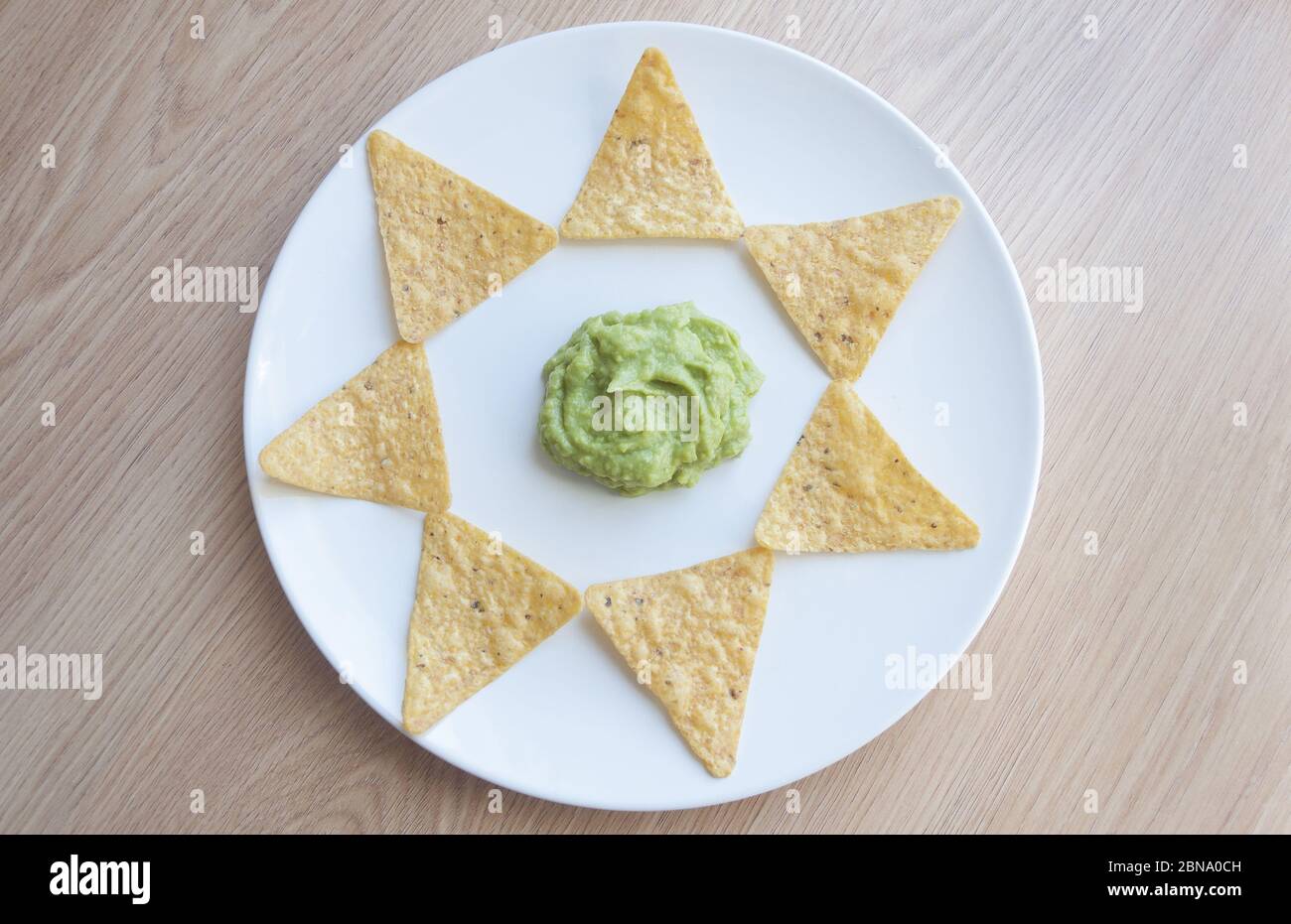 Beautiful shot of potato chips on a plate with homemade salsa Verde sauce Stock Photo